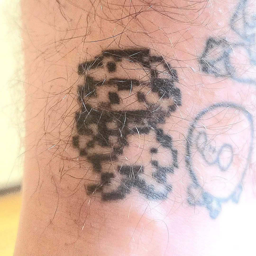 Pixelated character new school tattoo on the forearm by π«