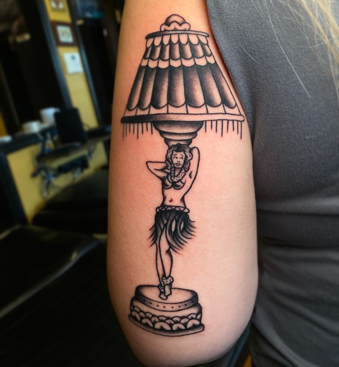 Lampshade with hula dancer black and grey tattoo on the forearm by Marcos🇩🇴