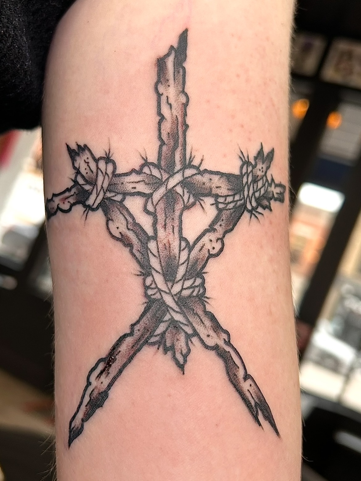 Cross with thorns black and grey tattoo on the forearm by Alex Fannin