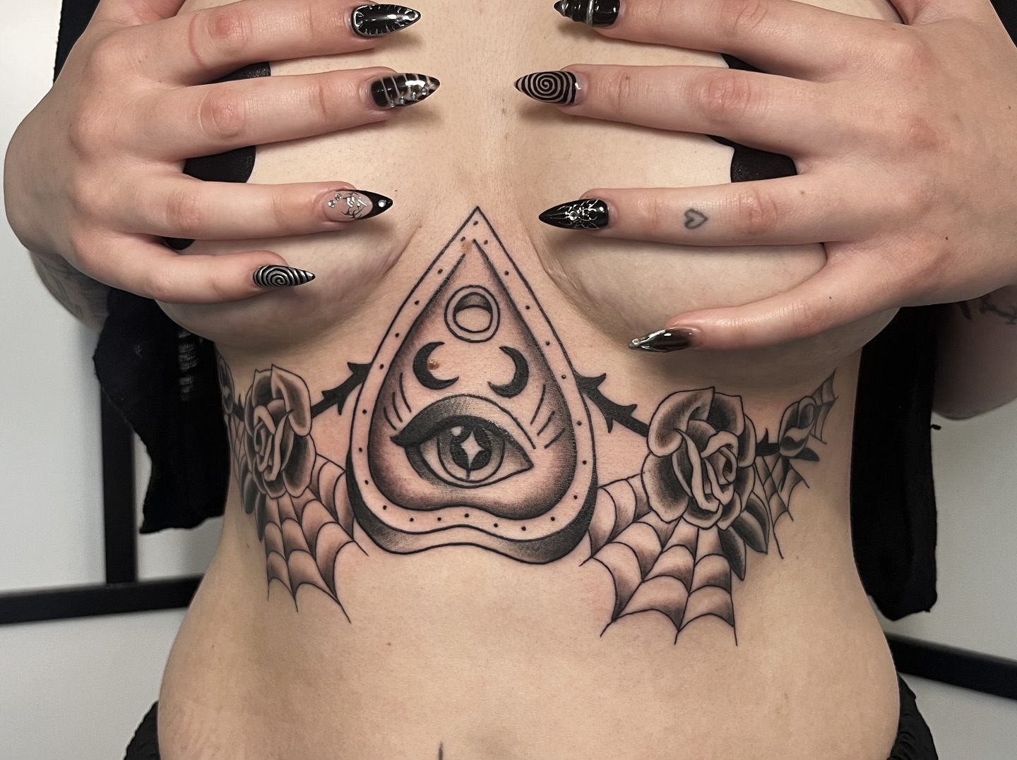 Eye and roses American traditional tattoo on the ribs by Taylor Newton