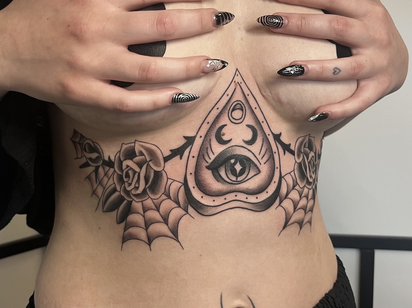 Eye and roses dotwork tattoo on the torso by Taylor Newton