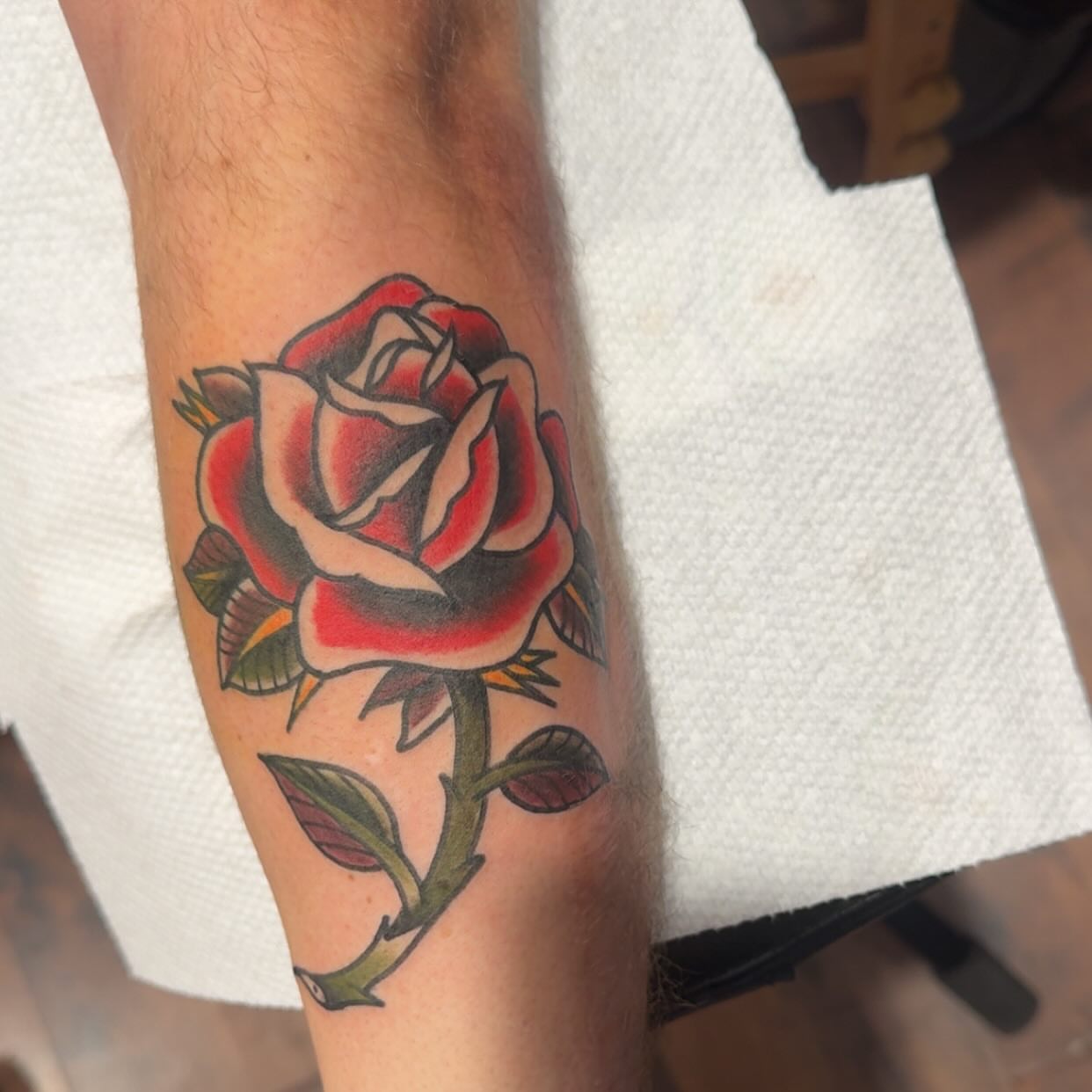 Rose American traditional tattoo on the forearm by Robbie Roberson