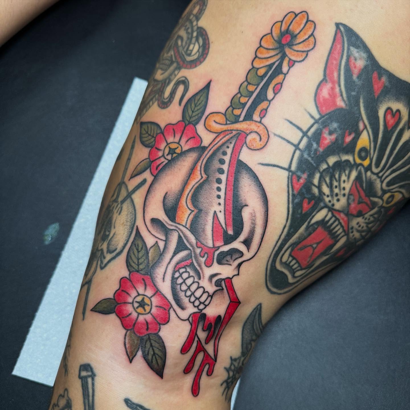 Skull and flowers American traditional tattoo on the forearm by Hannah Edwards, Austin, Texas