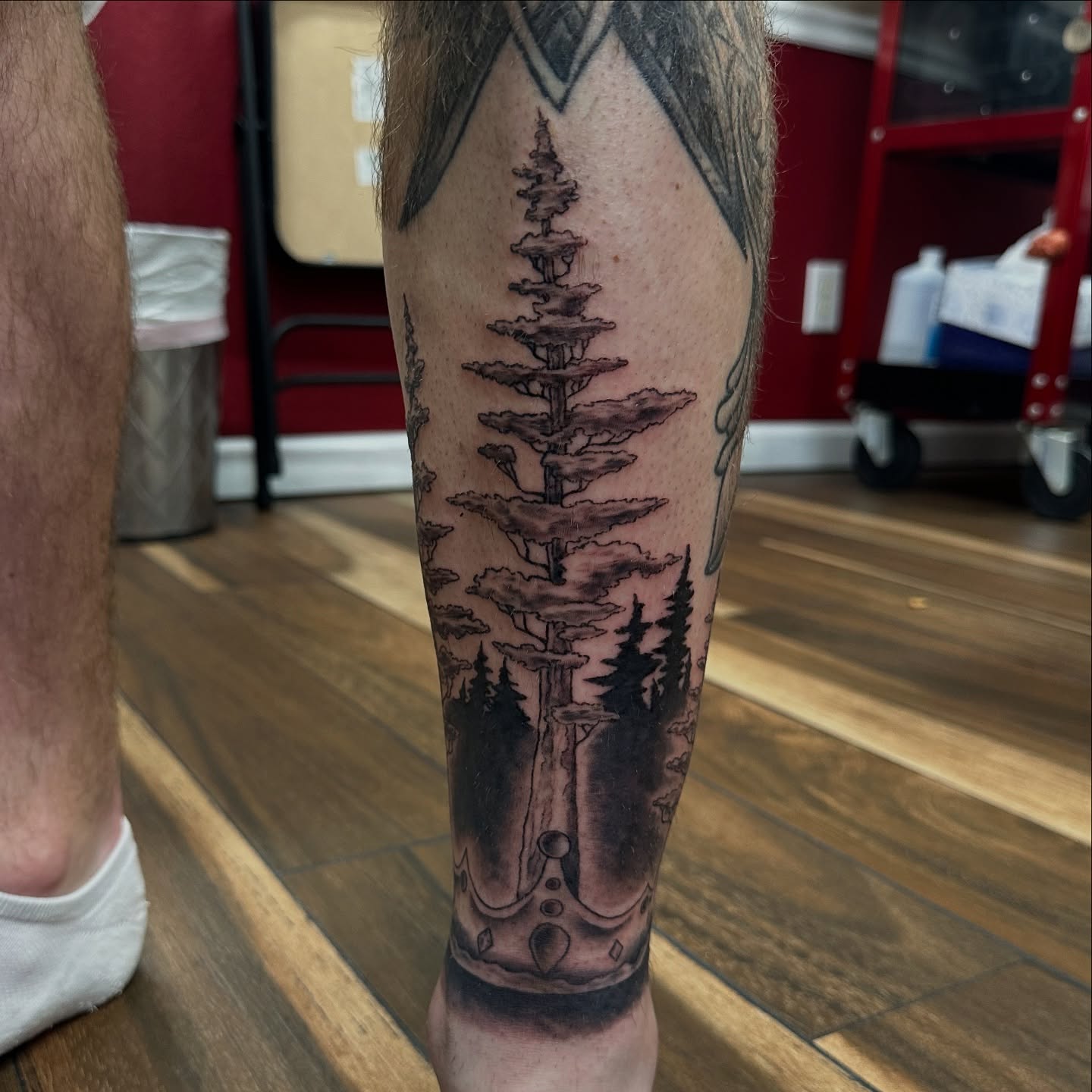 Pine tree black and grey tattoo on the forearm by Bosco Layne