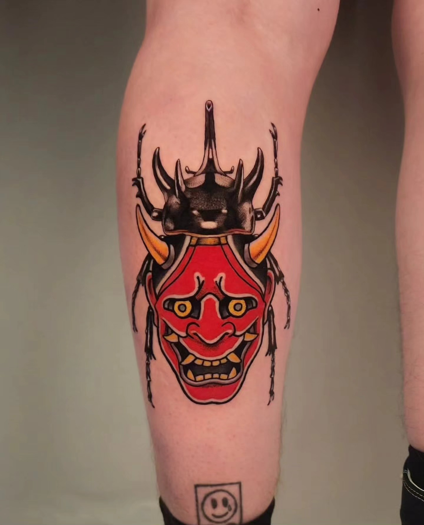 Mask American traditional tattoo on the calf by Whitney Caskey