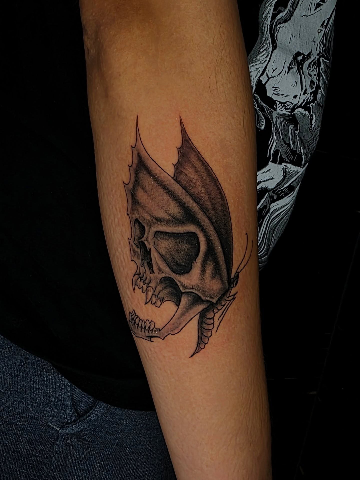 Skull with butterfly wings realism tattoo on the forearm by Bry True