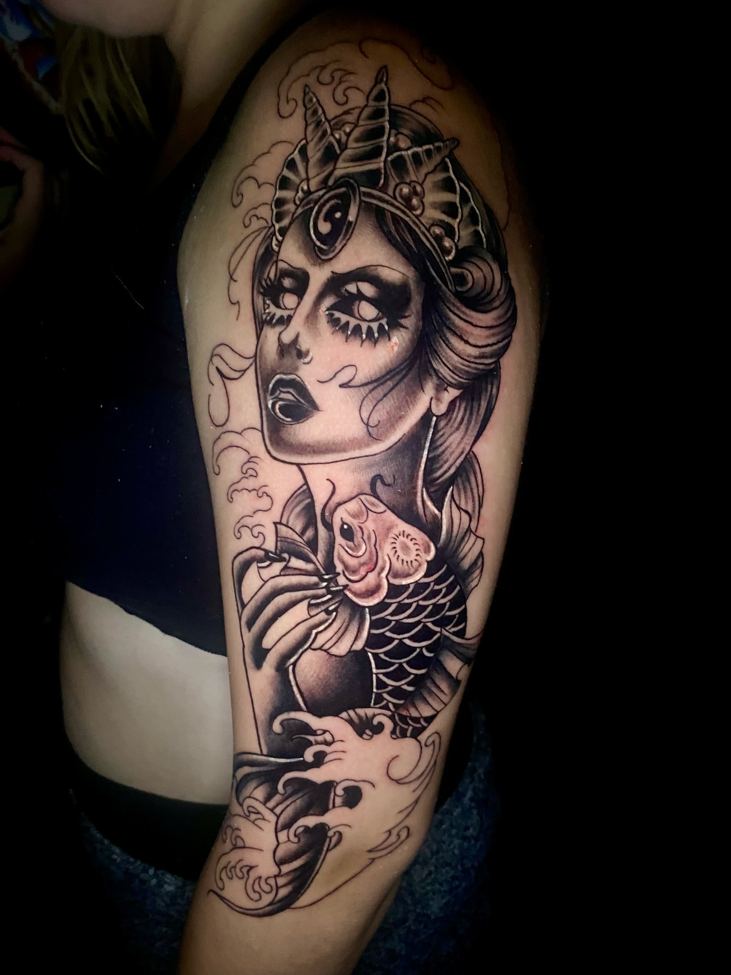 Woman with fish American traditional tattoo on the upper arm by Ashley Lin Las Vegas Tattoo Artist