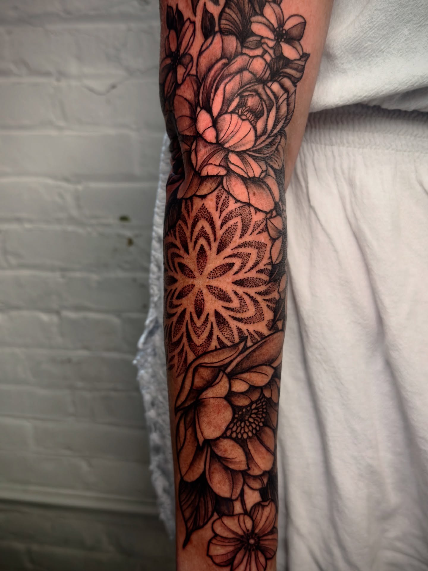 Floral bouquet dotwork tattoo on the forearm by Jeff Brock