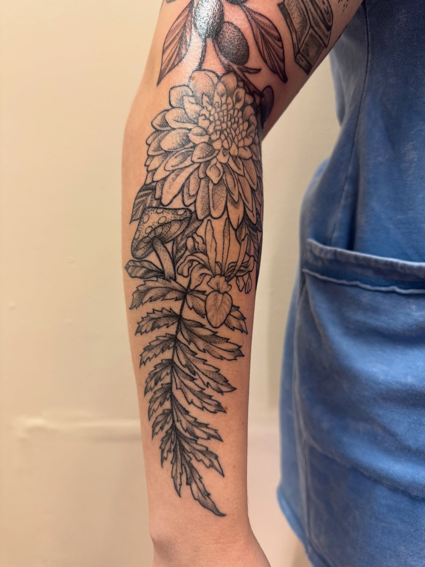 Floral arrangement black and grey tattoo on the forearm by Erin Moore