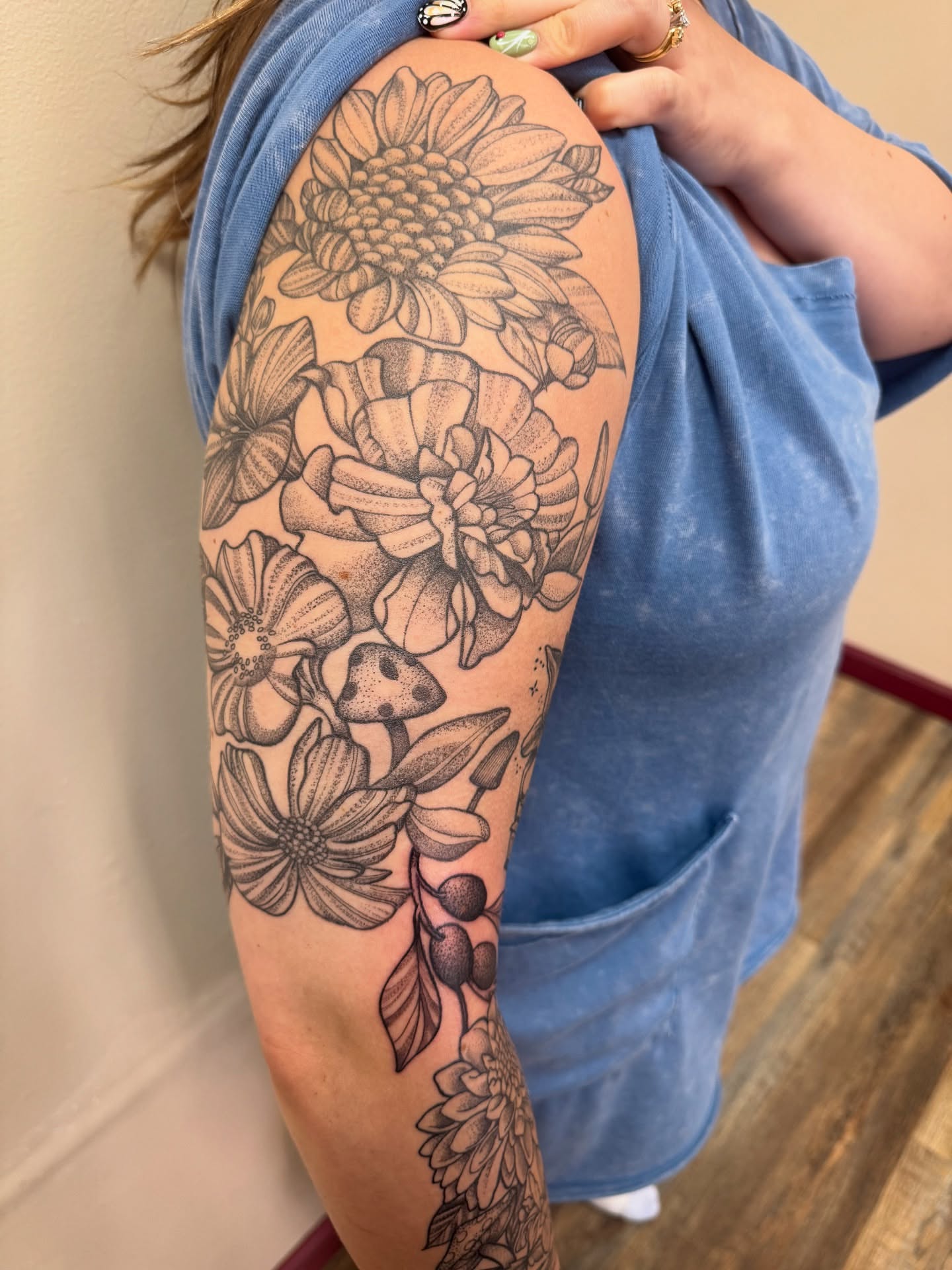 Floral arrangement dotwork tattoo on the upper arm by Erin Moore