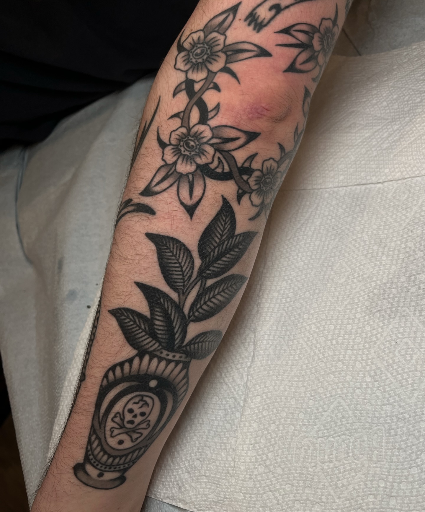 Flower and plant black and grey tattoo on the forearm by kate