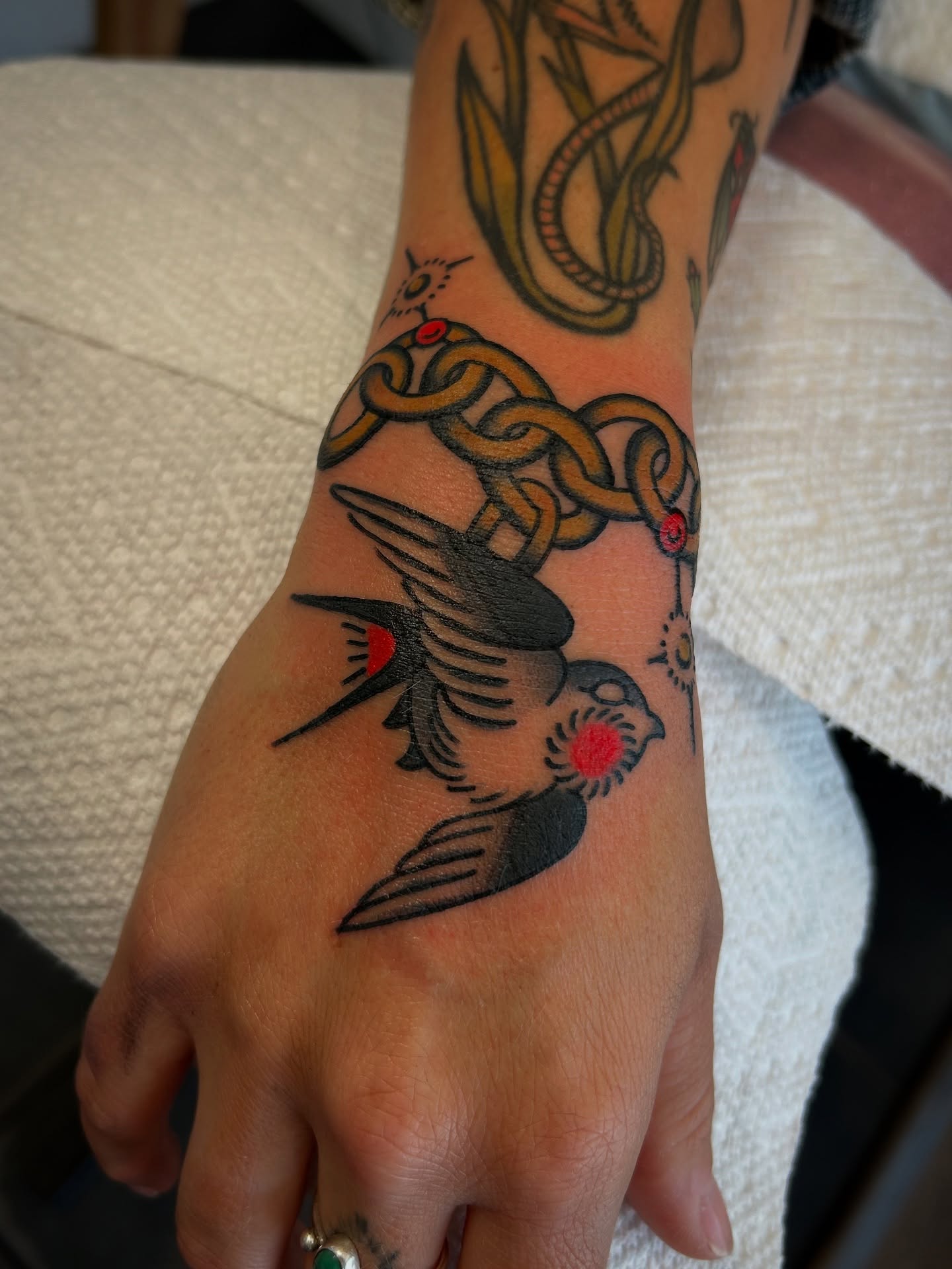 Swallow and knot American traditional tattoo on the forearm by Lilly Binns