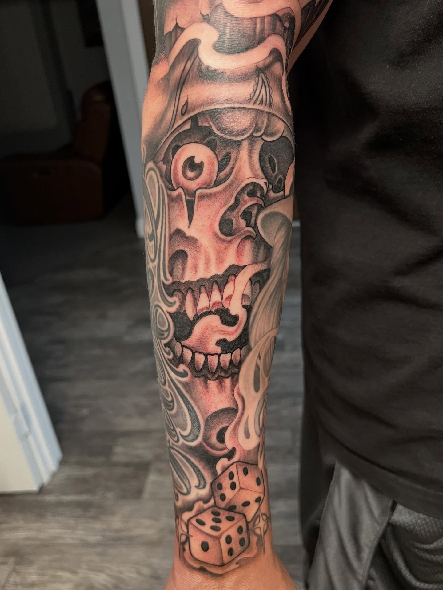 Skull and dice realism tattoo on the forearm by Niz Carrillo