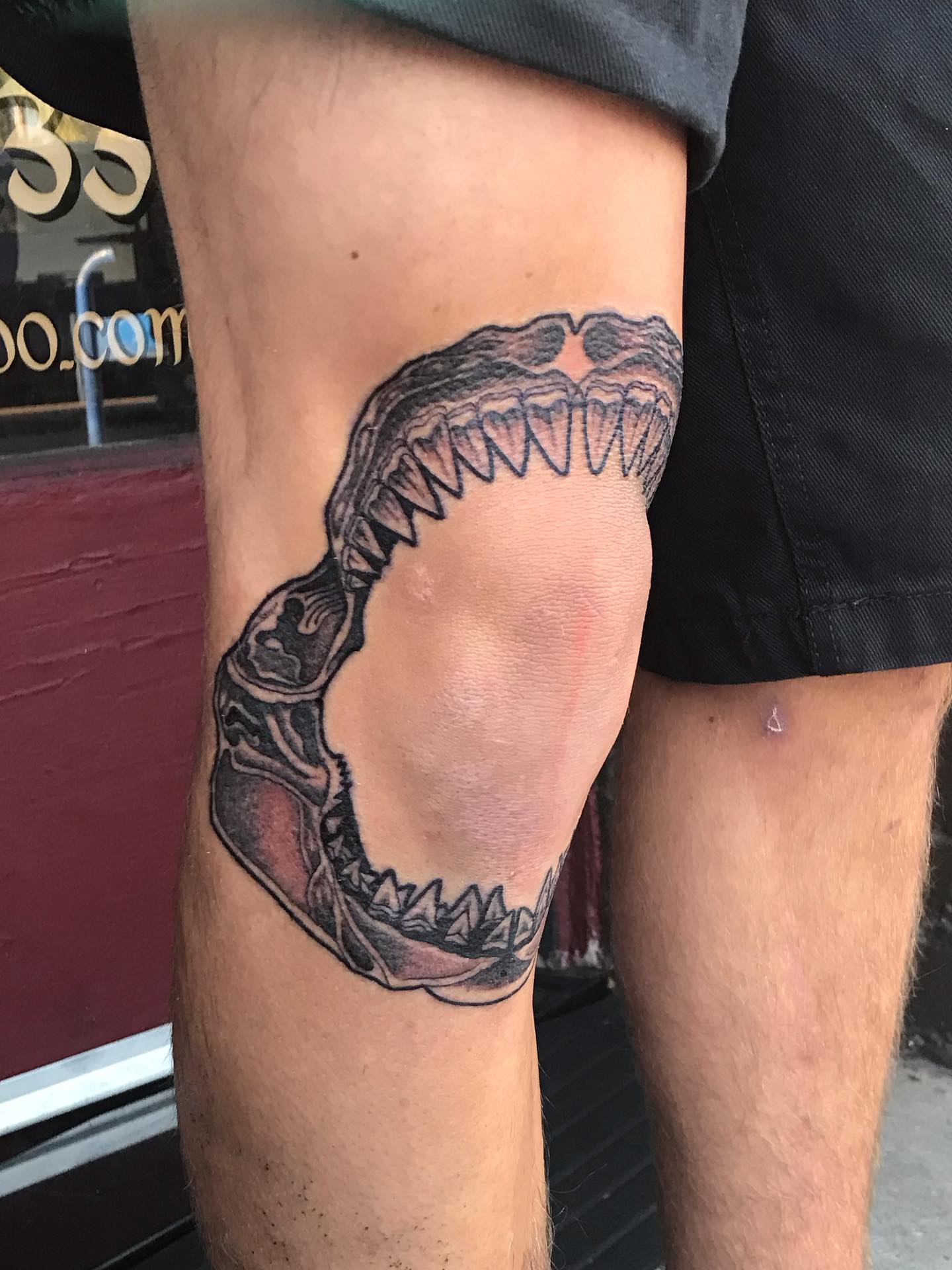 Jaws black and grey tattoo on the thigh by Sean Hollinger