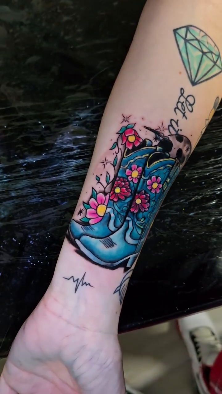 Cowboy boots with flowers American traditional tattoo by Jesse James, Las Vegas, Nevada