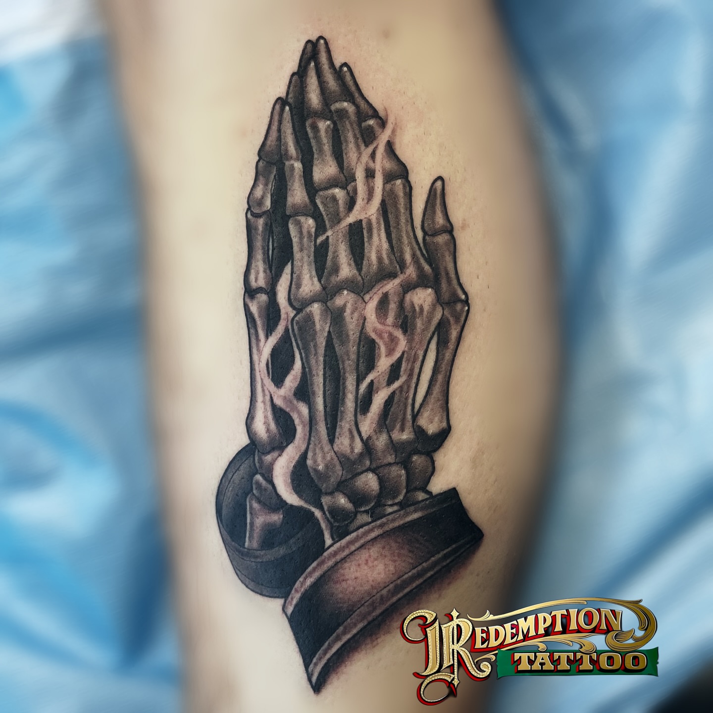 Praying skeleton hands black and grey tattoo on the forearm by Dorrough Tattooer
