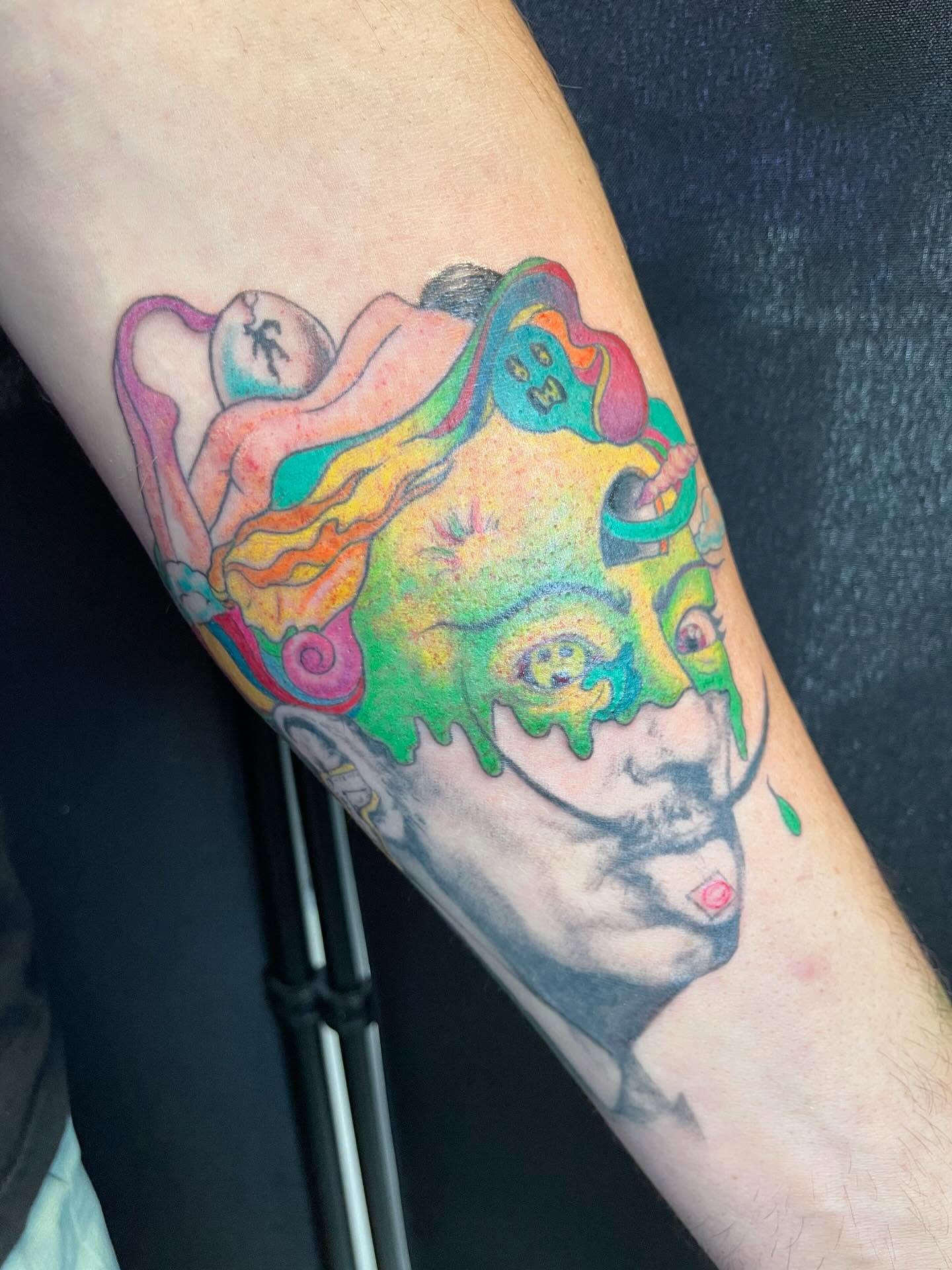 Melting face surrealism tattoo on the forearm by Christin Baumgart