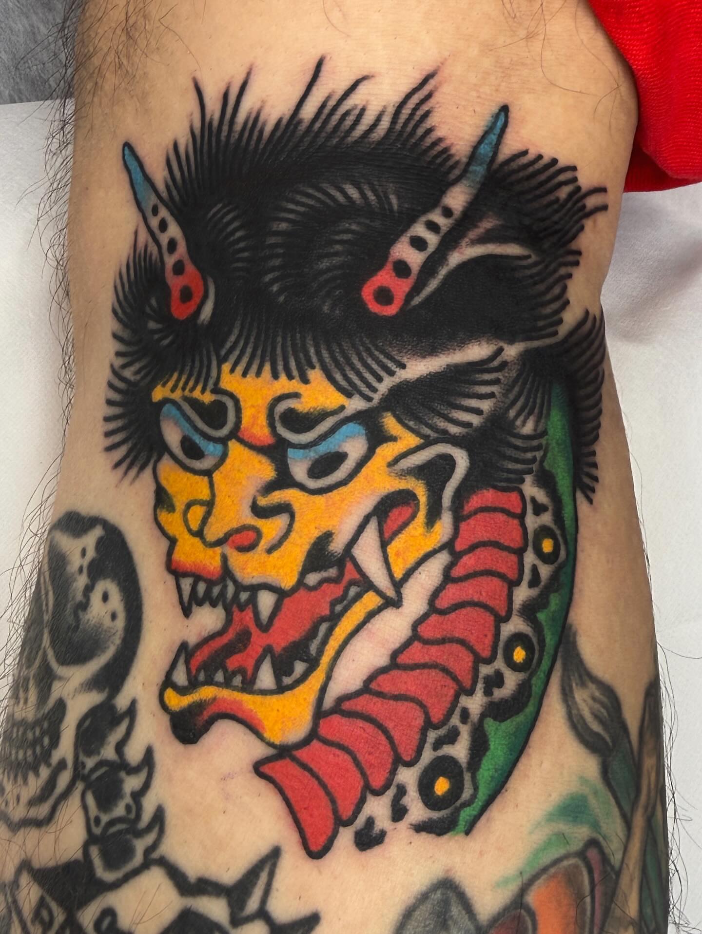 Demon mask American traditional tattoo on the forearm by Jimmy Ho