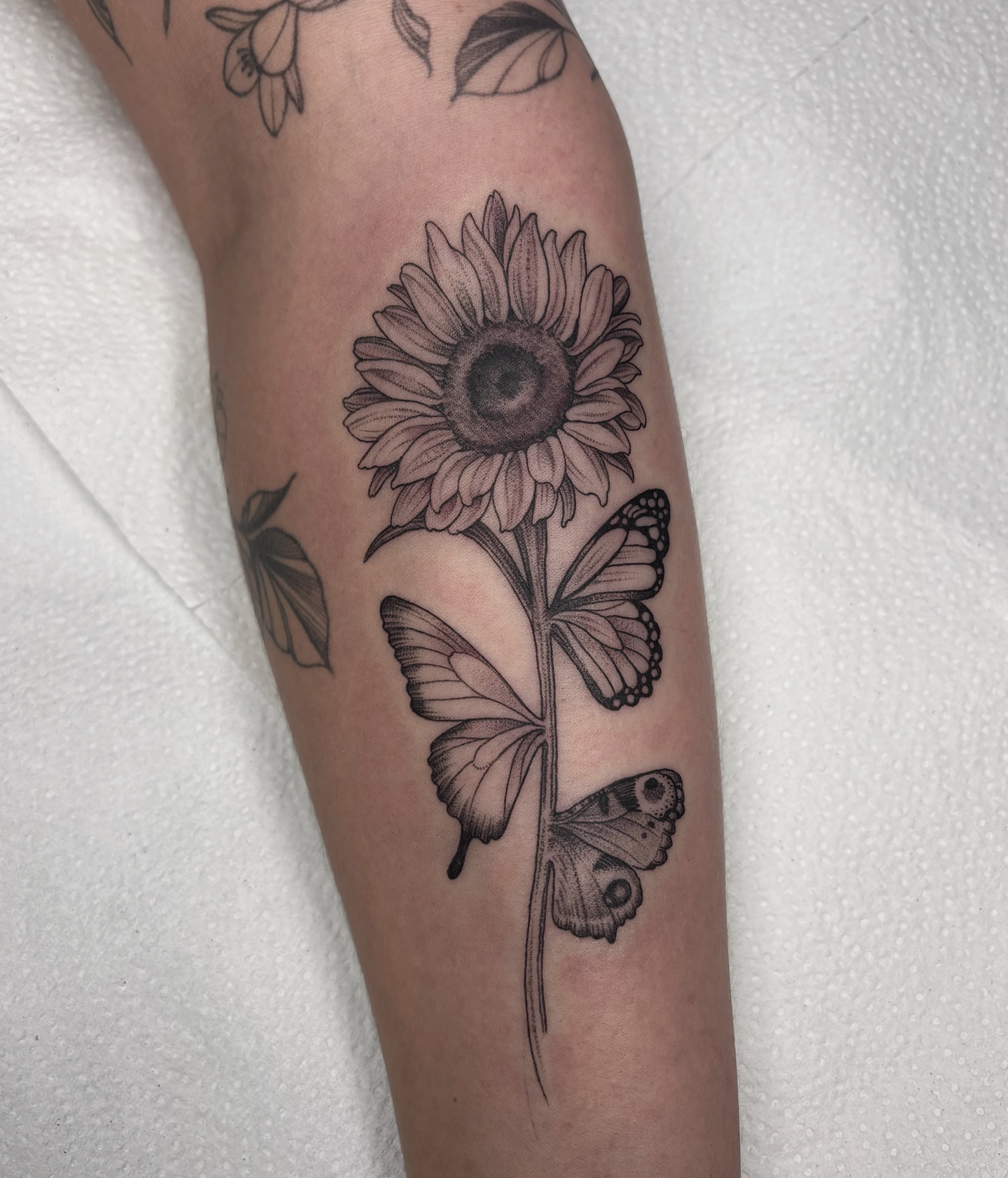 Sunflower and butterflies realism tattoo on the forearm by Kinsey Miller