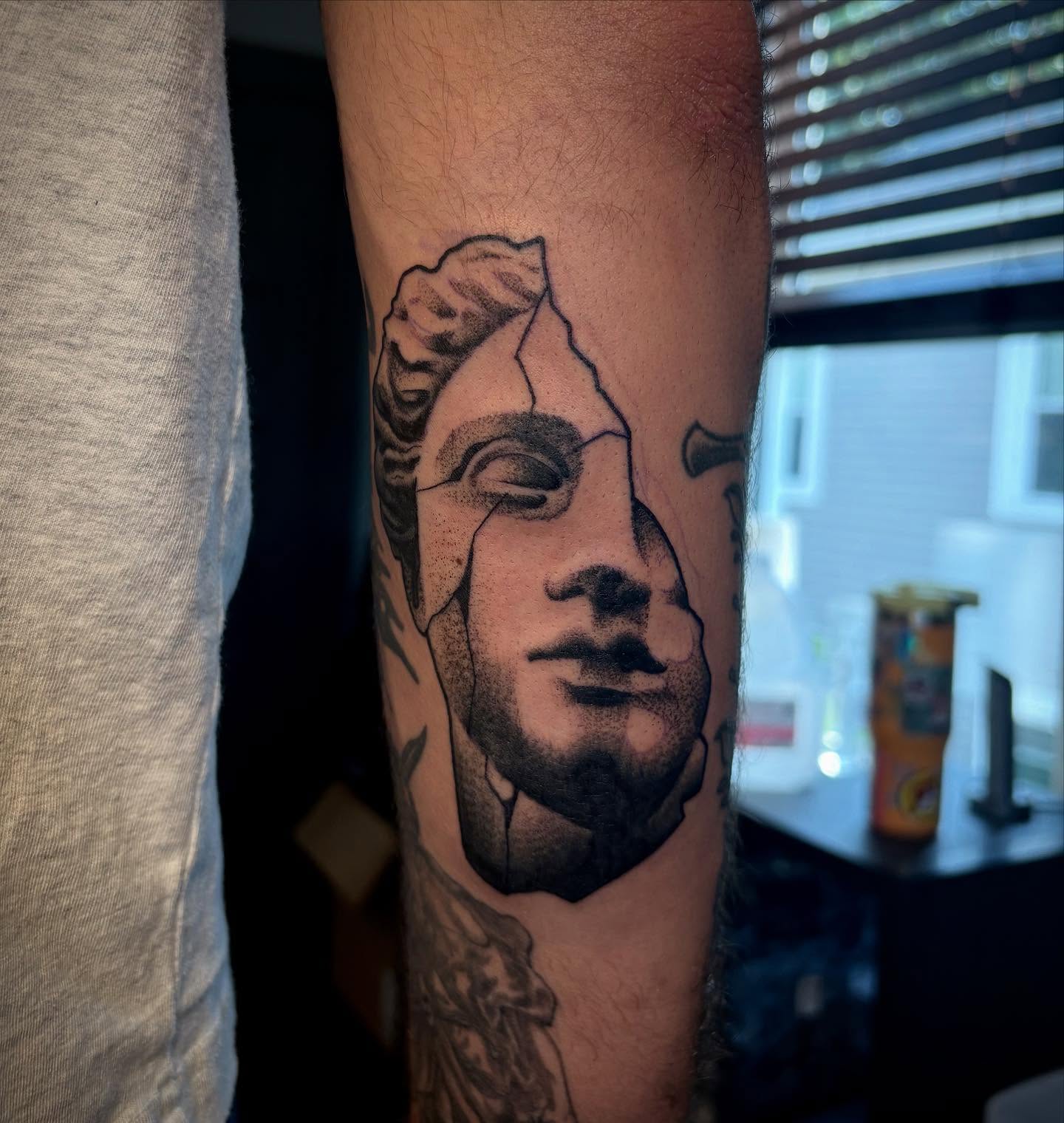 Statue head black and grey tattoo on the forearm by Nolan Croteau