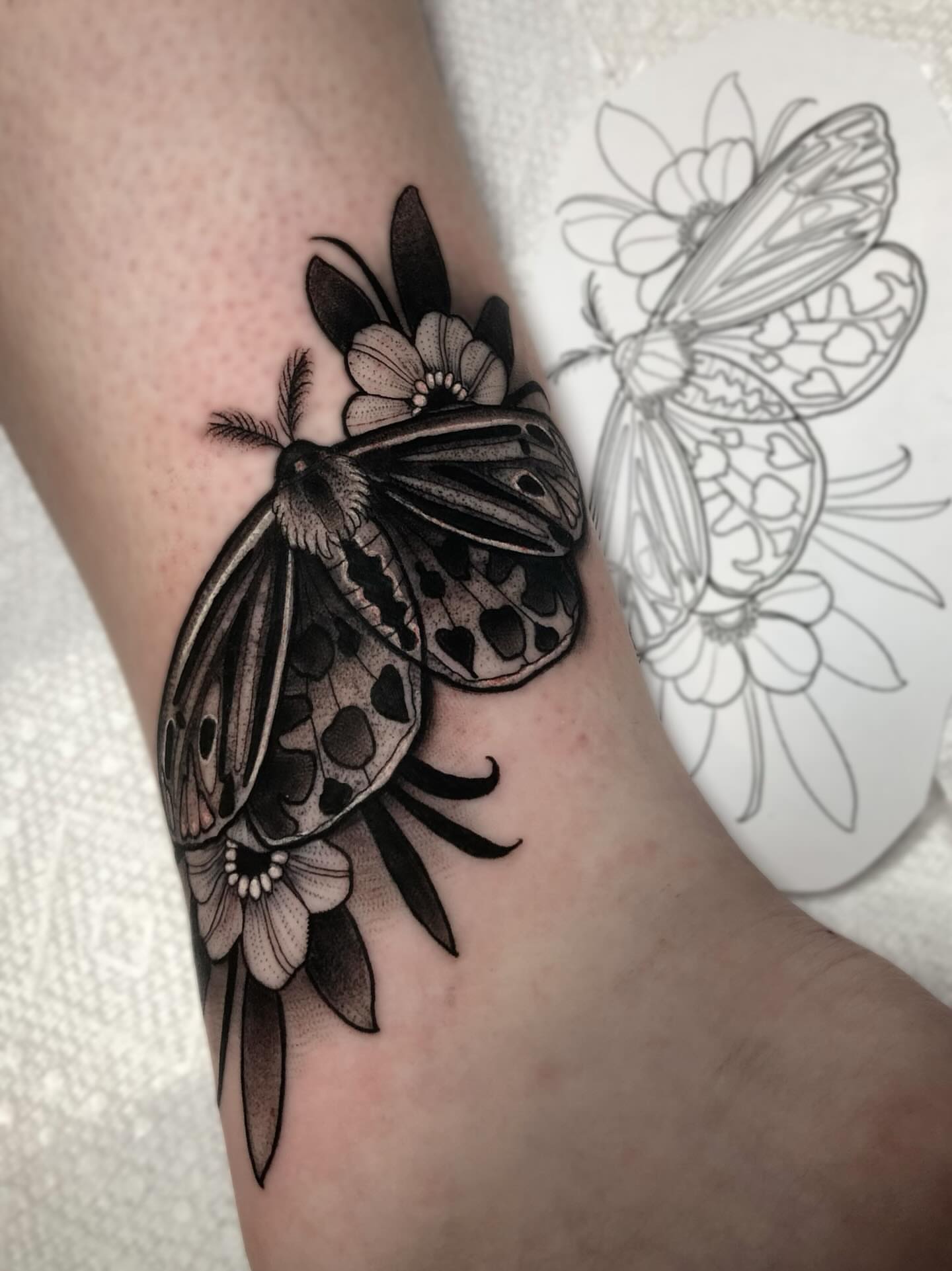 Moth and flowers realism tattoo on the forearm by Melissa Brown
