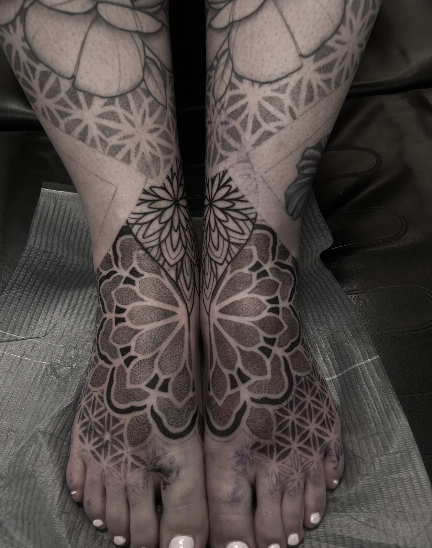 Geometric floral pattern dotwork tattoo on the foot by Christofer Irvin