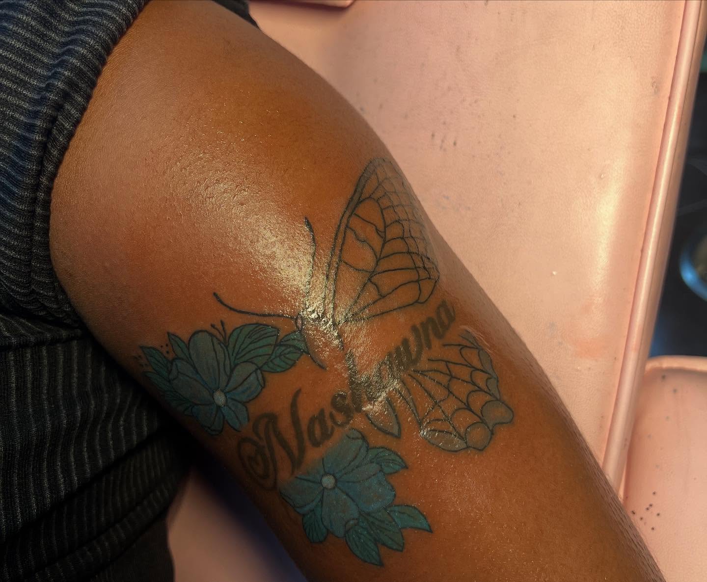 Butterfly and flowers black and grey tattoo on the forearm by Tatted By Layy