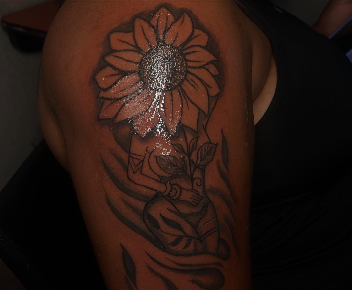 Sunflower and woman black and grey tattoo on the shoulder by Tatted By Layy