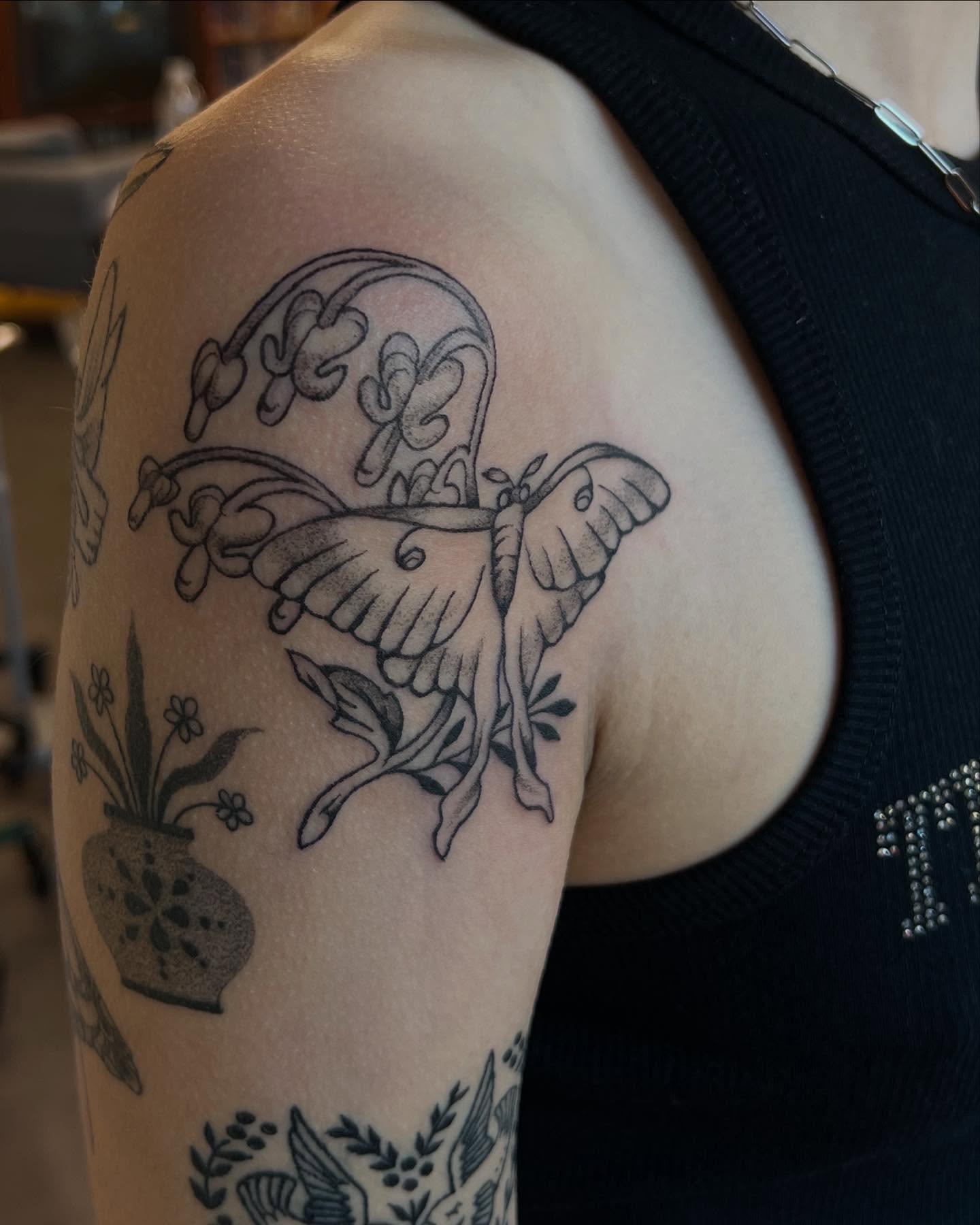 Butterfly and floral arrangement black and grey tattoo on the shoulder by rachel