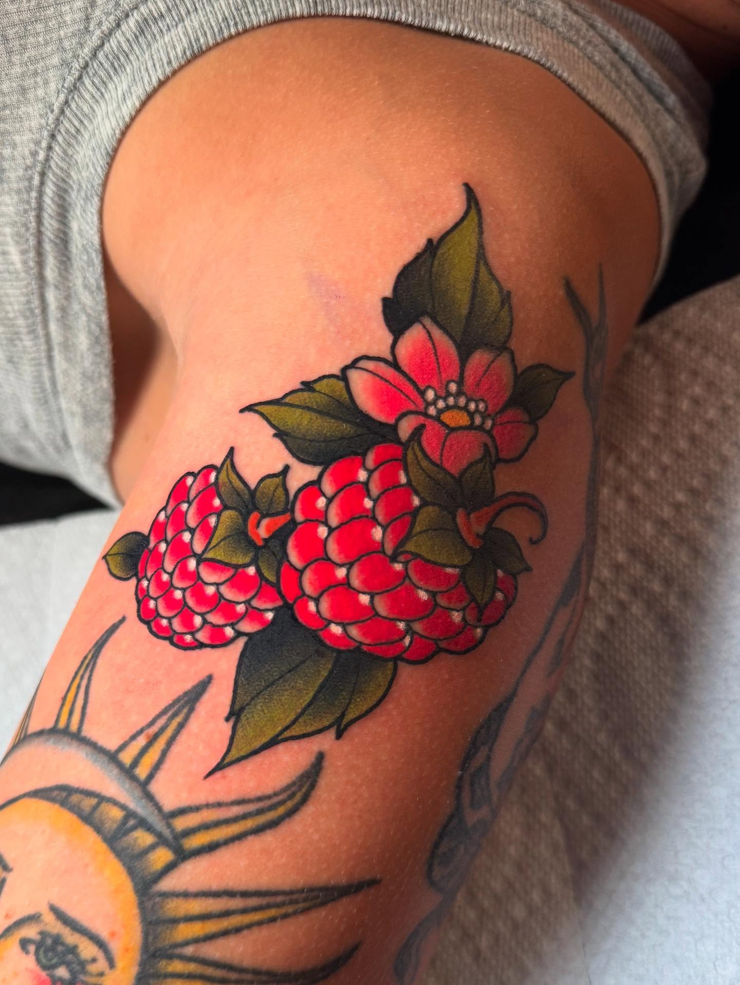 Raspberry and flower American traditional tattoo on the thigh by Jess Longfield, Des Moines, Iowa