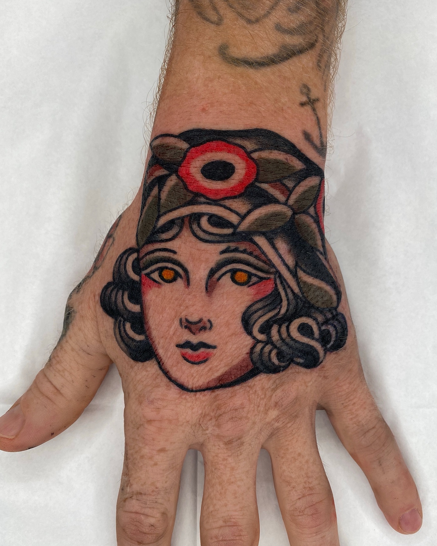 Woman's face American traditional tattoo on the hand by Wes Hoffman