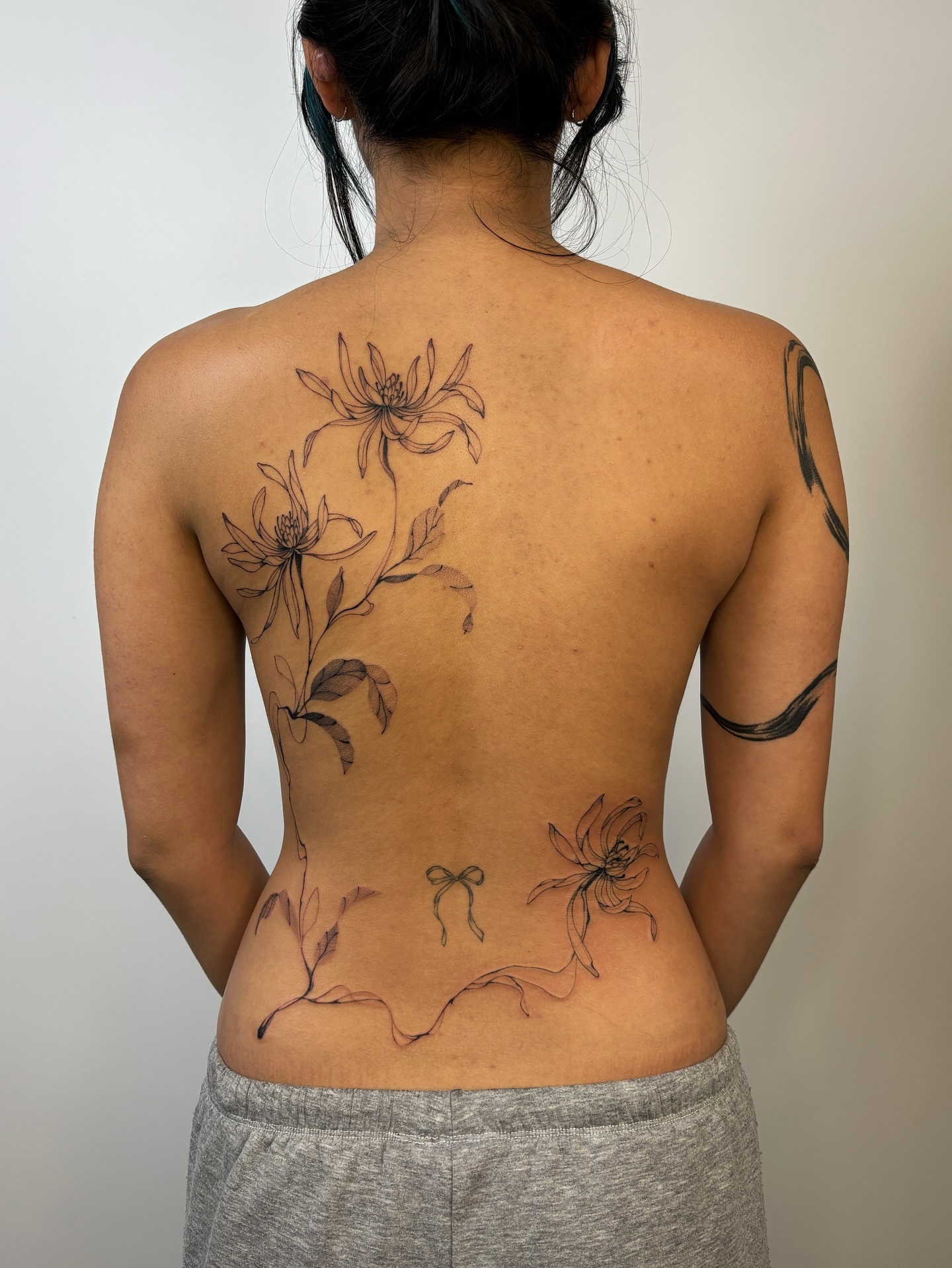 Floral arrangement realism tattoo on the back by sago, Berkeley, California