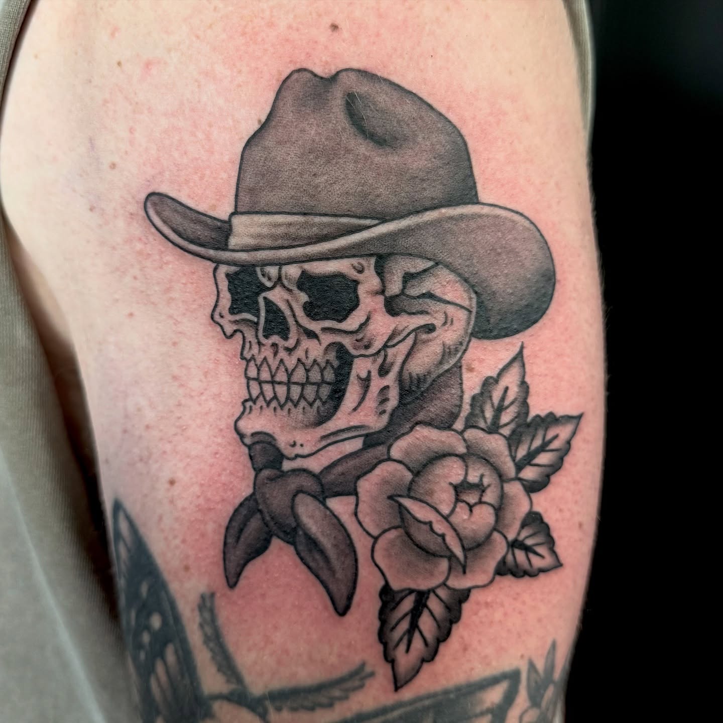 Cowboy skull with roses American traditional tattoo on the forearm by Ernie Rivera