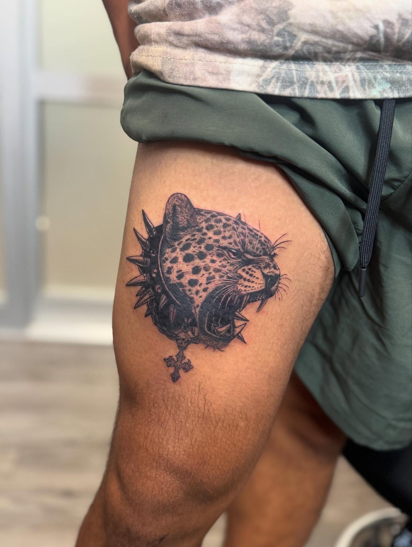 Leopard black and grey tattoo on the thigh by Gladys L.
