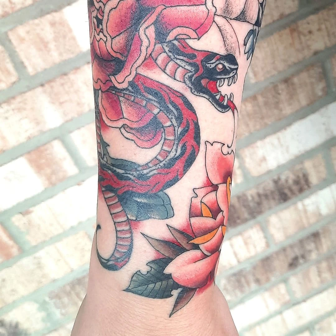 Snake and peony American traditional tattoo on the forearm by Kaetlyn