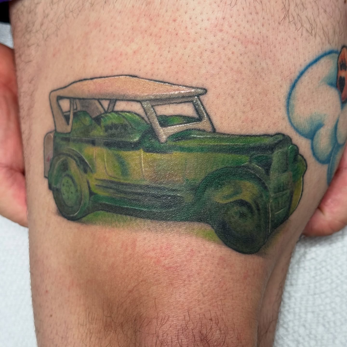 Green golf cart realism tattoo on the thigh by Lacee-Beth Finch