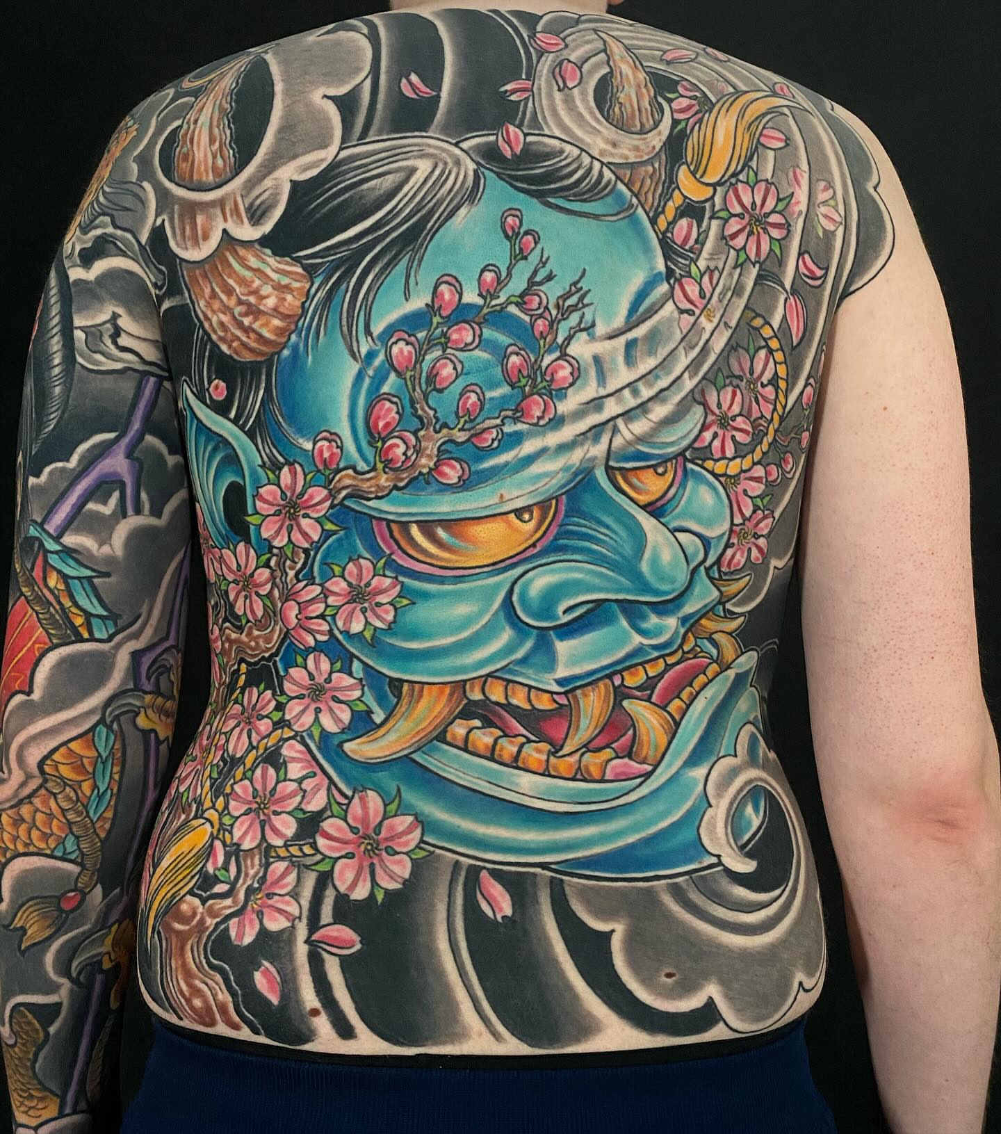 Mask with cherry blossoms japanese irezumi tattoo on the back by John Milosh Chamberlin