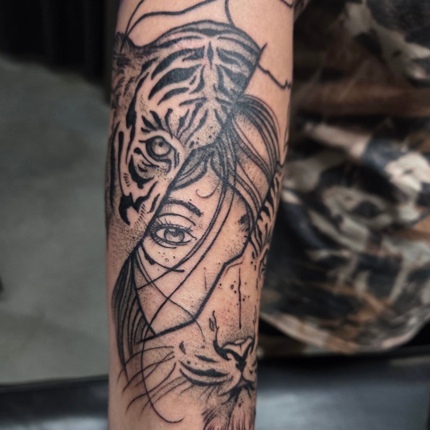 Woman and tiger dotwork tattoo on the forearm by Jamie Clinton