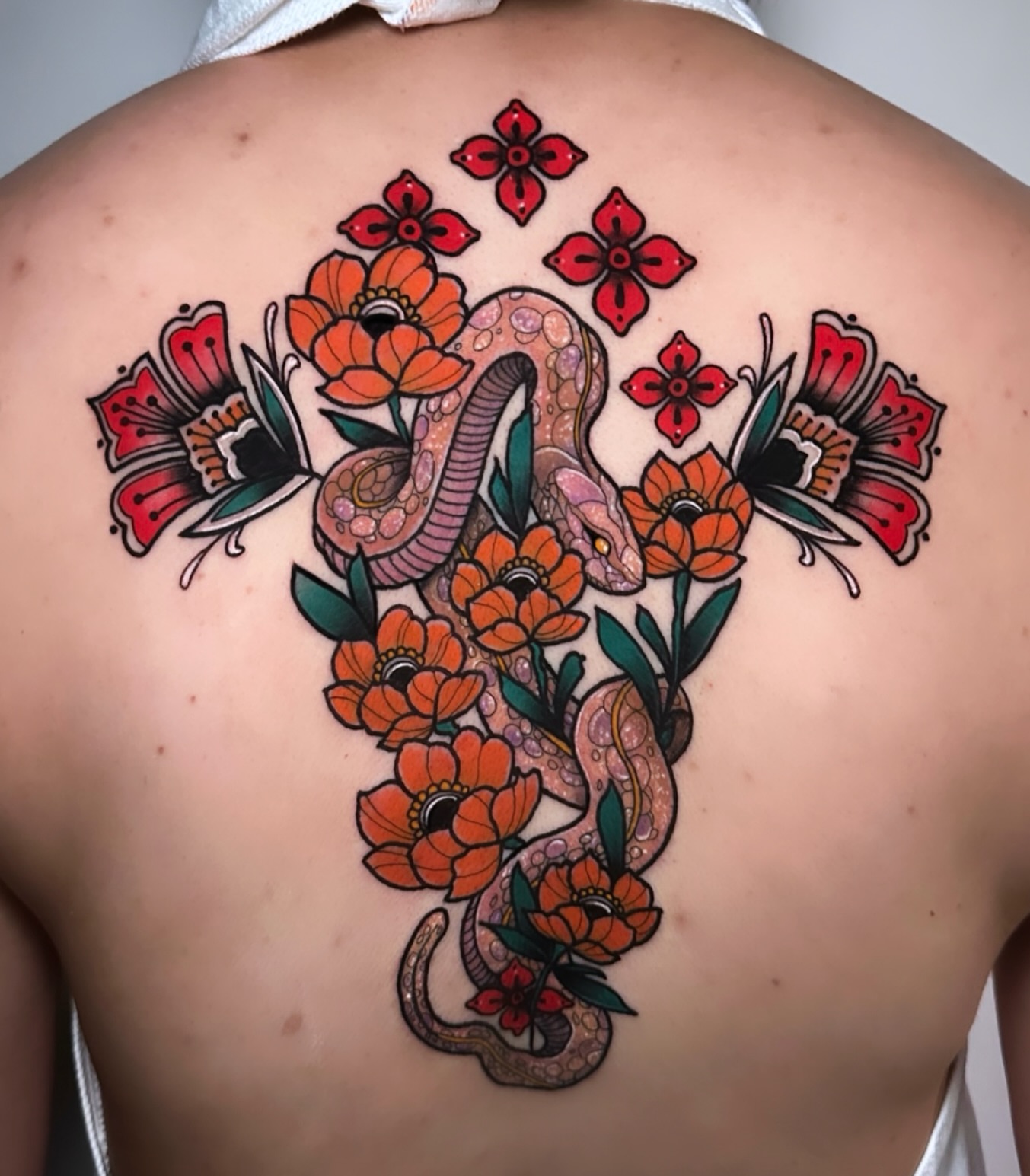 Snake and flowers American traditional tattoo on the back by Naysla Droguett