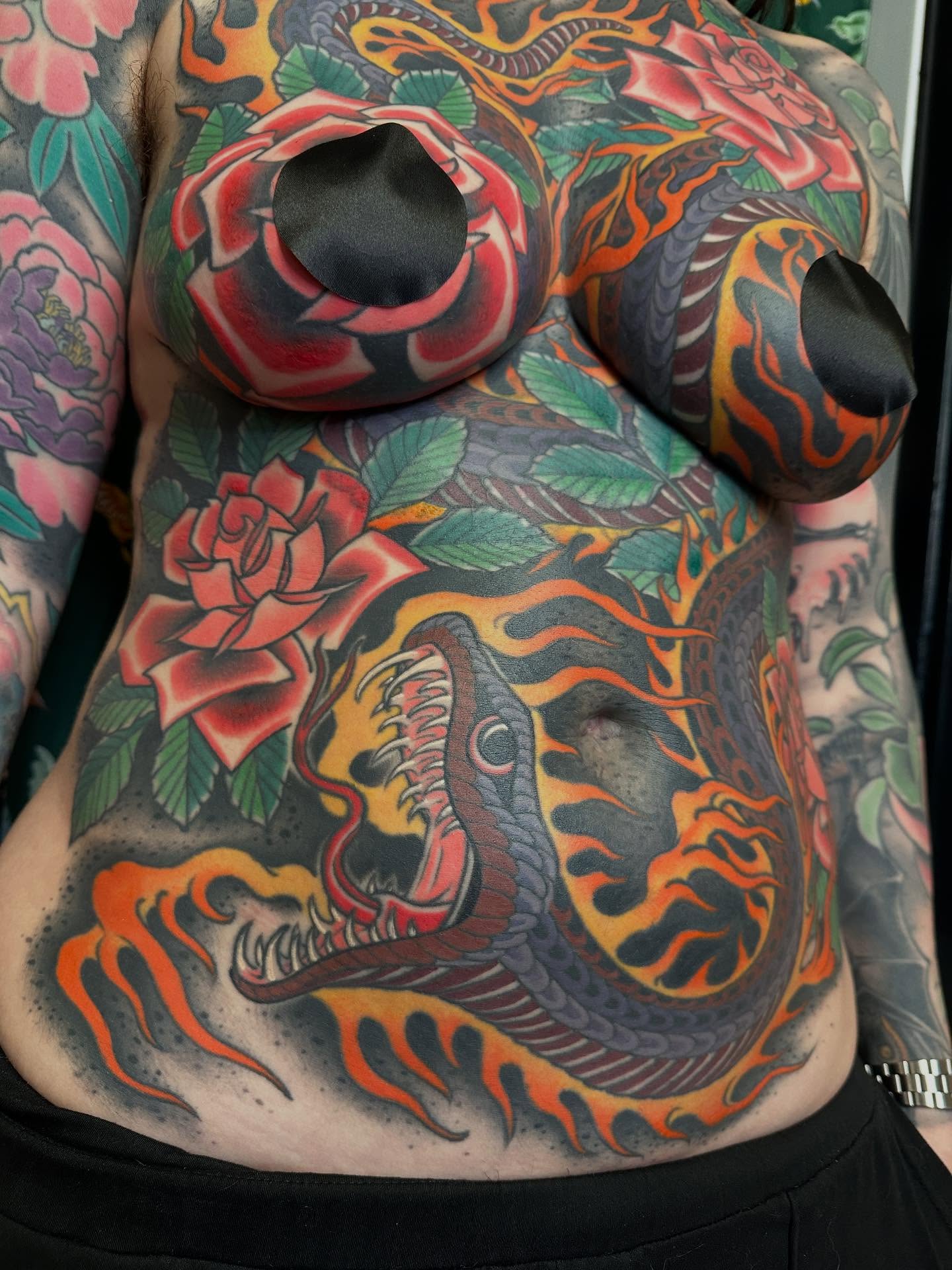 Snake and roses American traditional tattoo on the chest by Megon Shore, Seattle, Washington