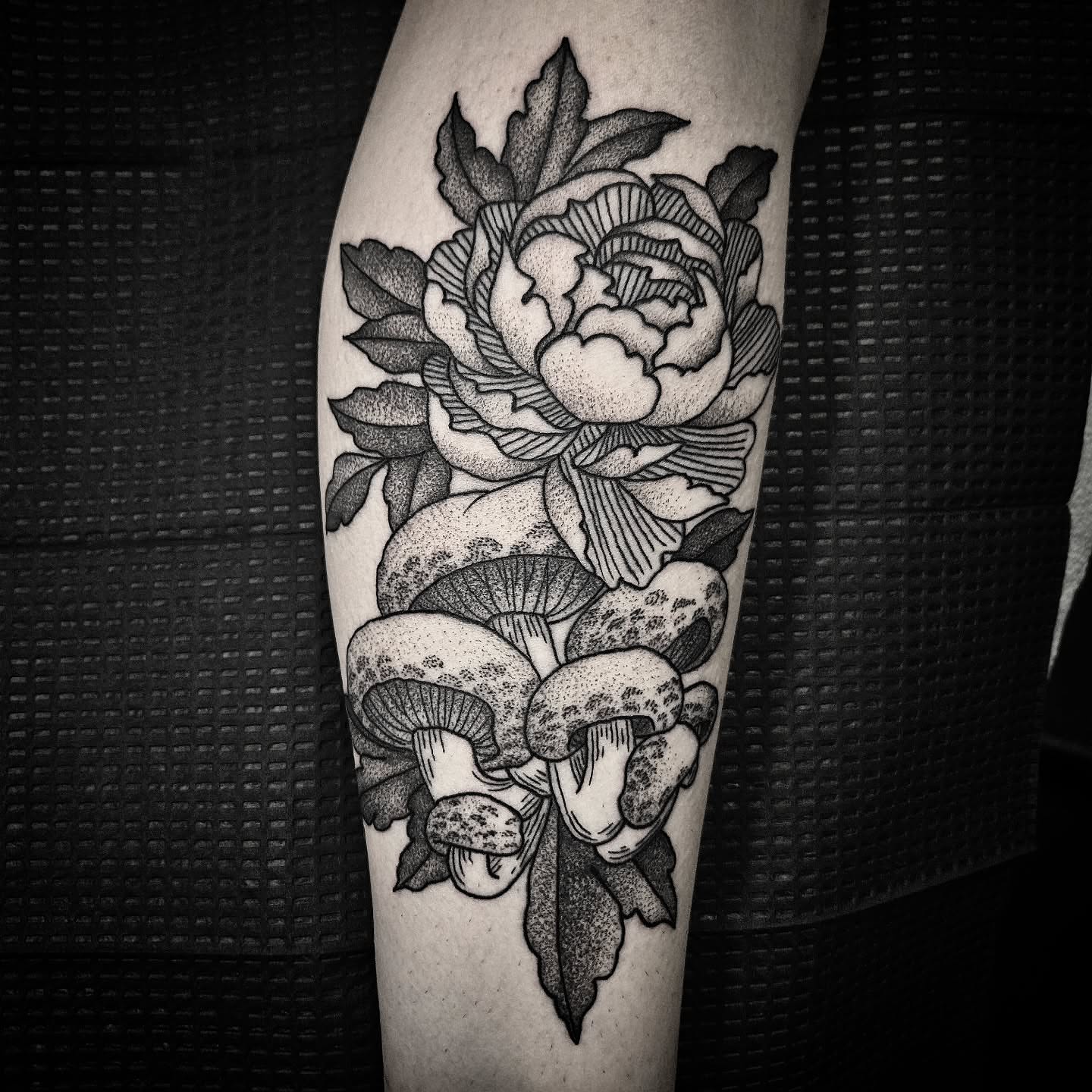 Peony and mushrooms dotwork tattoo on the forearm by Kirk George