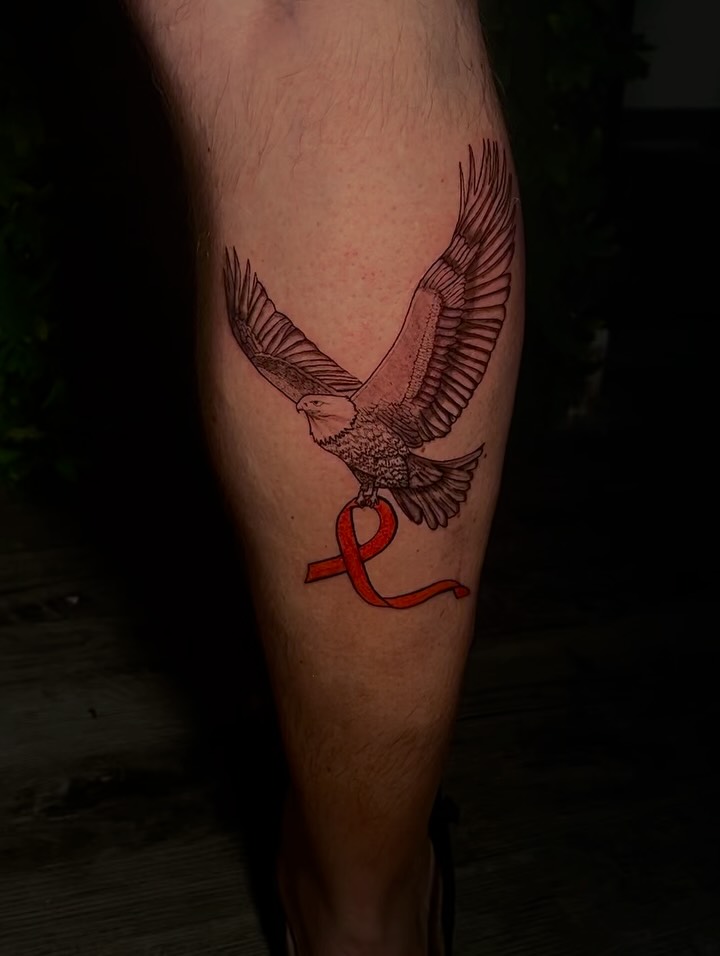 Eagle with ribbon black and grey tattoo on the leg by @tattsbyleek