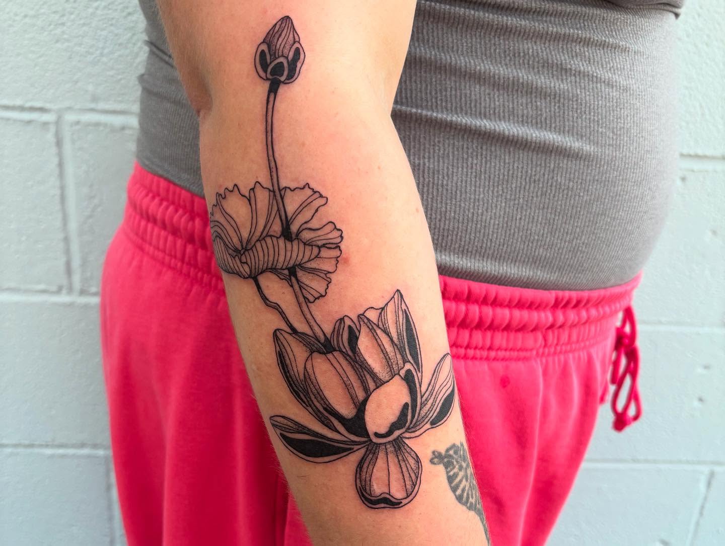 Lotus flower black and grey tattoo on the forearm by Ashley Ellerman