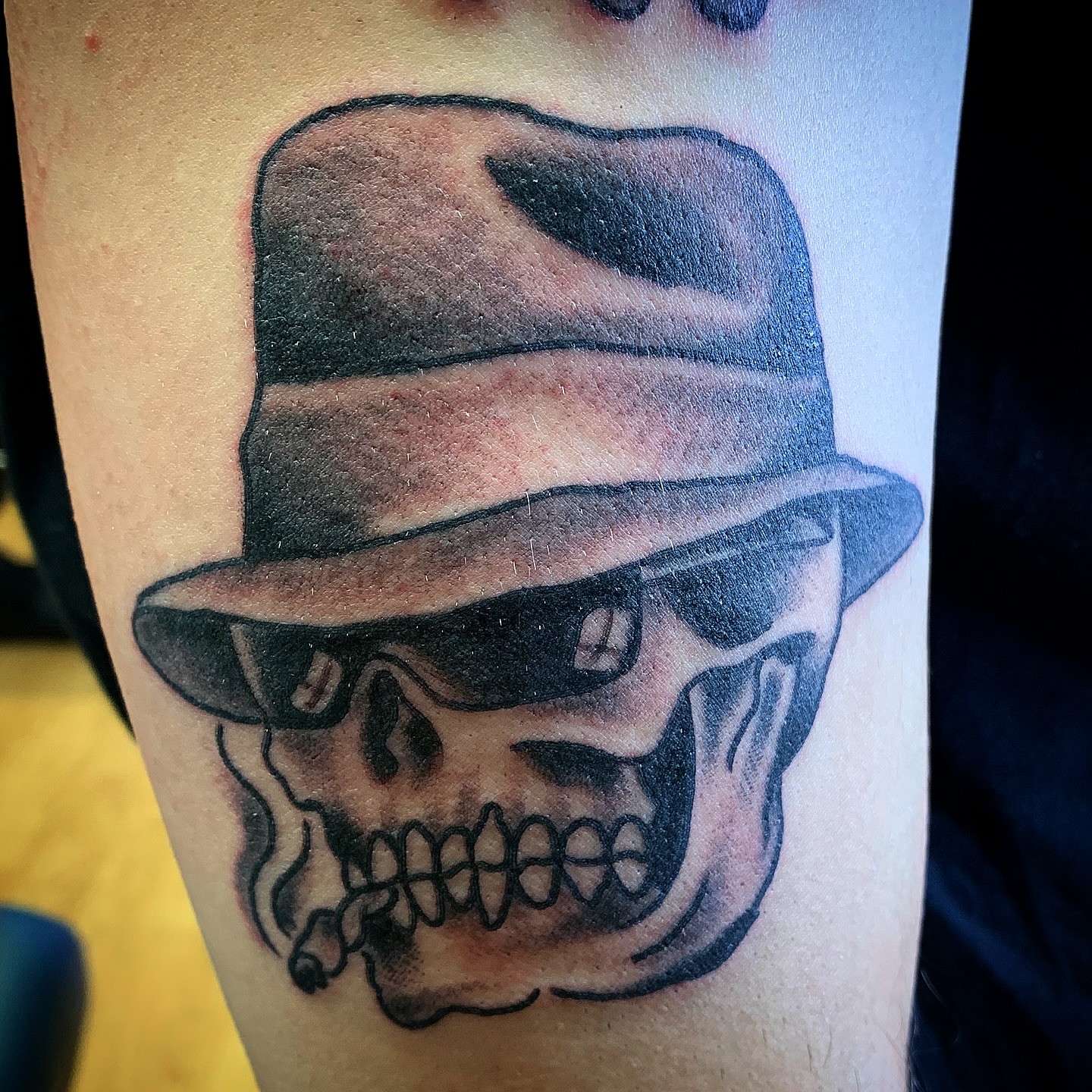Skull wearing hat black and grey tattoo on the forearm by Tattoos Las Vegas,NV