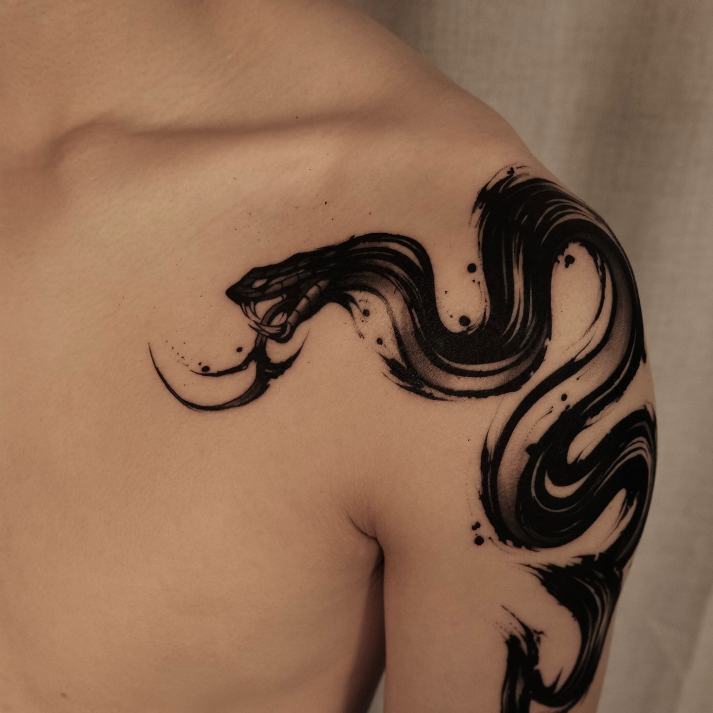 Snake black and grey tattoo on the shoulder by Houston Tattoo Artist