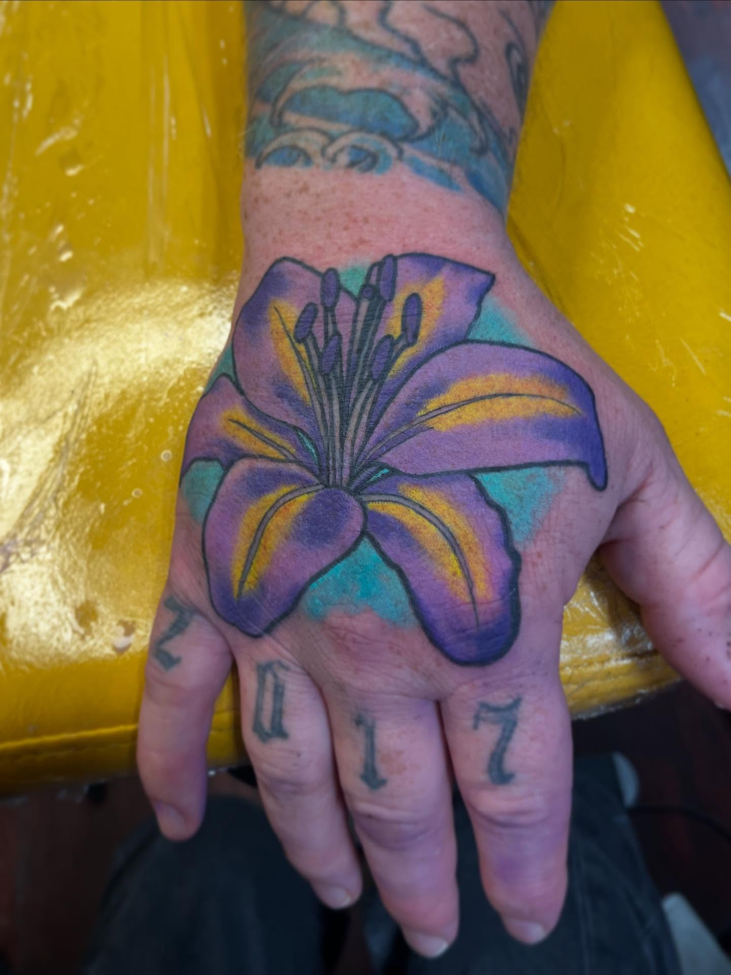Lily new school tattoo on the hand by Riley McDonald