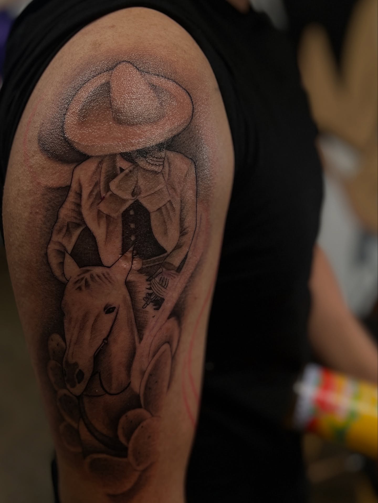 Man with sombrero realism tattoo on the upper arm by @divineink_nyc