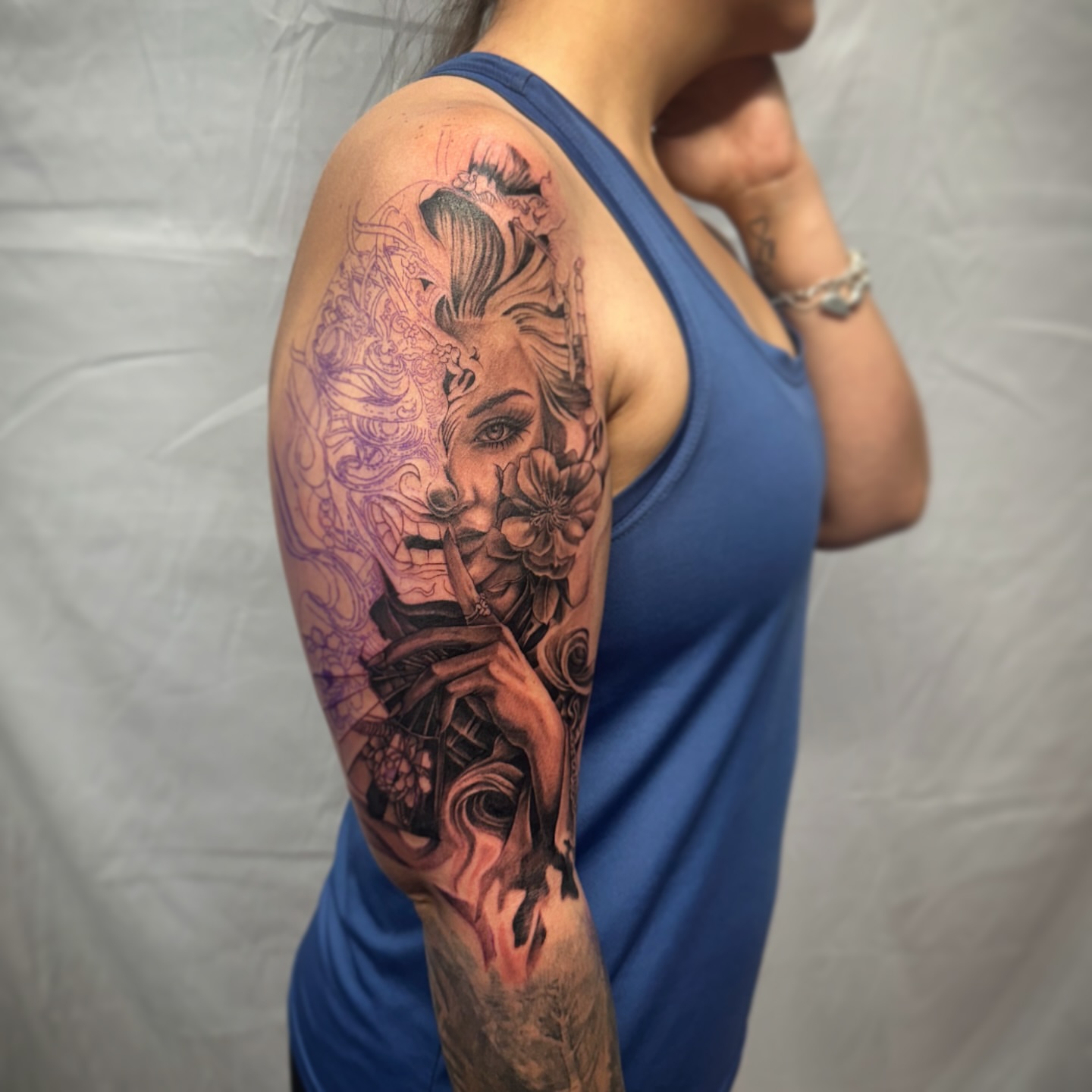 Woman with flowers realism tattoo on the upper arm by Elizabeth’s Eclectic Tattoos