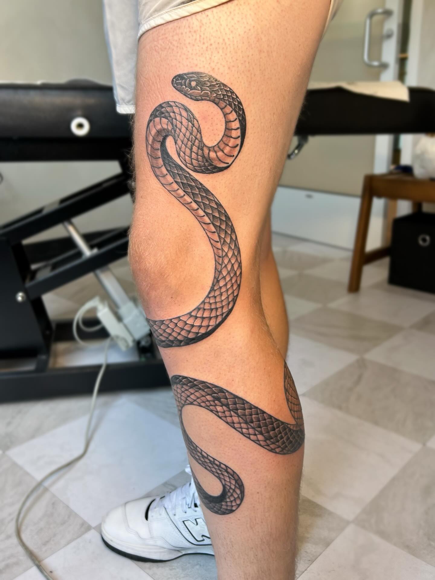 Snake black and grey tattoo on the leg by kuna ink