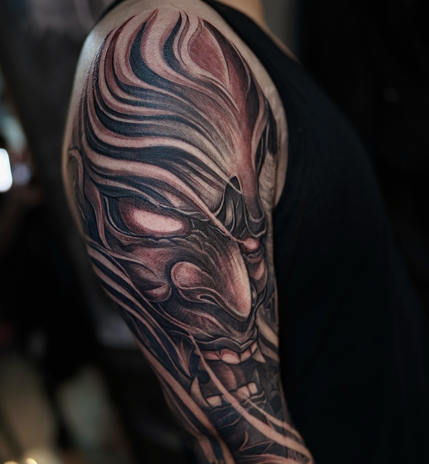Mask dark realism tattoo on the upper arm by Thien Phan